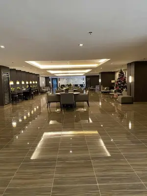 a lobby with a christmas tree and a table and chairs at Stylish 1BR Air Residences Wifi & Netflix in Manila