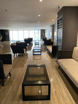 a lobby with couches and tables in a building at Stylish 1BR Air Residences Wifi & Netflix in Manila