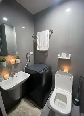 a bathroom with a white toilet and a sink at Stylish 1BR Air Residences Wifi & Netflix in Manila