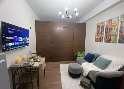 a living room with a couch and a tv at Stylish 1BR Air Residences Wifi & Netflix in Manila