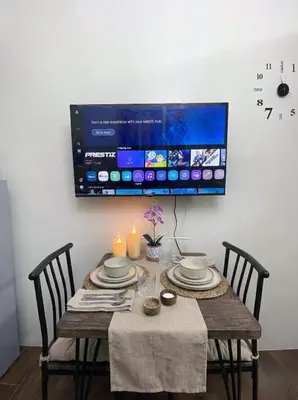 a dining room table with two chairs and a tv at Stylish 1BR Air Residences Wifi & Netflix in Manila