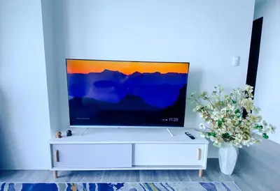 a tv on top of a white cabinet in a living room at 2BR Luxurious Ocean View, close Okada, Solaire, MOA, Airport with free parking in Manila