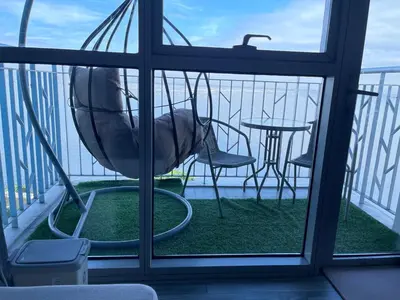 a view of a balcony with a swing and a table at 2BR Luxurious Ocean View, close Okada, Solaire, MOA, Airport with free parking in Manila