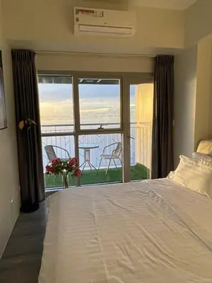 a bedroom with a bed and a view of the ocean at 2BR Luxurious Ocean View, close Okada, Solaire, MOA, Airport with free parking in Manila