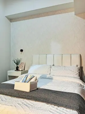 a bedroom with a large bed with a white headboard at Park Mckinley West Luxury 1Br Suite in Manila