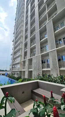 a large apartment building with a bench in front of it at Park Mckinley West Luxury 1Br Suite in Manila