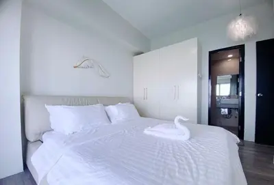 a white bed with a swan on top of it at 2BR With Magnificent Bayview GARDEN View Near Okada, Solaire, Airports, Free Parking in Manila