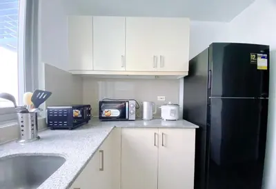 a kitchen with a black refrigerator and a microwave at 2BR With Magnificent Bayview GARDEN View Near Okada, Solaire, Airports, Free Parking in Manila