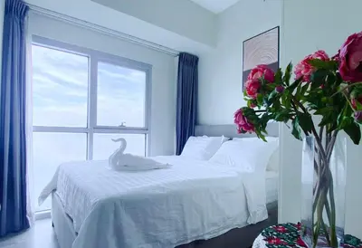 a bedroom with a white bed with a swan on it at 2BR With Magnificent Bayview GARDEN View Near Okada, Solaire, Airports, Free Parking in Manila