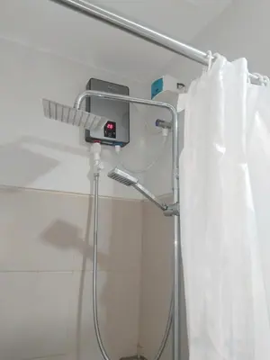 a shower with a white curtain in a bathroom at Feel at Home in Manila