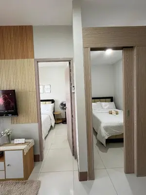 a hotel room with two beds and a television at Feel at Home in Manila