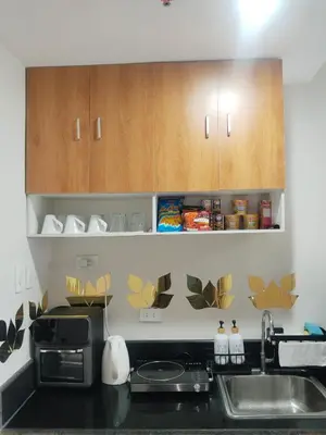 a kitchen with wooden cabinets and a sink at Feel at Home in Manila