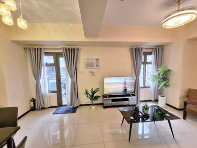 a living room with a television and a table at GOUTEI Homestay - The Radiance Manila Bay in Manila