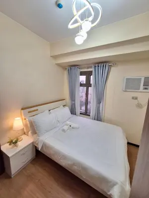 a bedroom with a large white bed with a window at GOUTEI Homestay - The Radiance Manila Bay in Manila