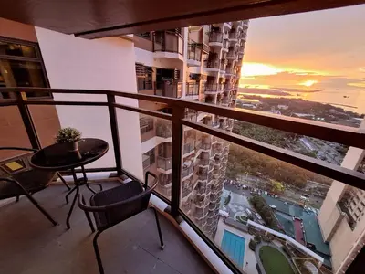 a balcony with a table and a view of a city at GOUTEI Homestay - The Radiance Manila Bay in Manila