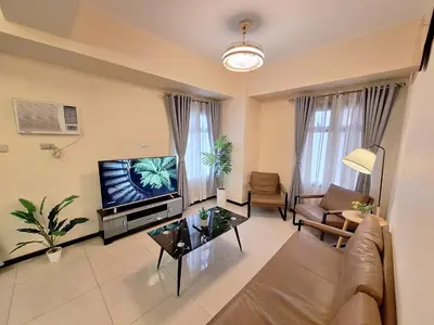 a living room with a couch and a tv at GOUTEI Homestay - The Radiance Manila Bay in Manila