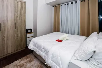 a bedroom with a white bed with flowers on it at Snooze & Stay in Manila