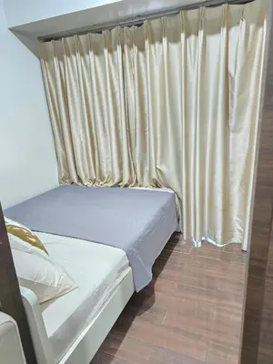 a bed in a room with a curtain at Mafresco Makati Staycation in Manila