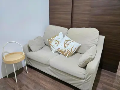 a white couch with pillows on it in a room at Mafresco Makati Staycation in Manila