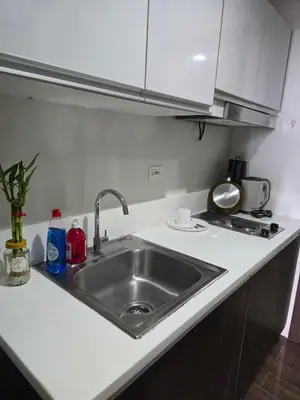 a kitchen counter with a sink and a stove at Mafresco Makati Staycation in Manila