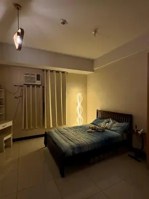 a bedroom with a bed with a light on it at J&A CondoStay Near NAIA Terminal 3 in Manila