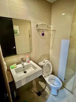 a bathroom with a sink and a toilet and a shower at J&A CondoStay Near NAIA Terminal 3 in Manila