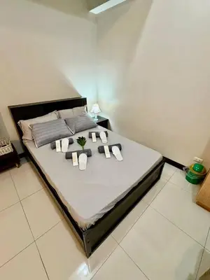 a large bed with towels and pillows on it at J&A CondoStay Near NAIA Terminal 3 in Manila