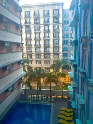 a large building with a swimming pool in front of it at J&A CondoStay Near NAIA Terminal 3 in Manila