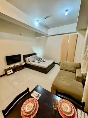 a room with a bed and a table and a couch at J&A CondoStay Near NAIA Terminal 3 in Manila