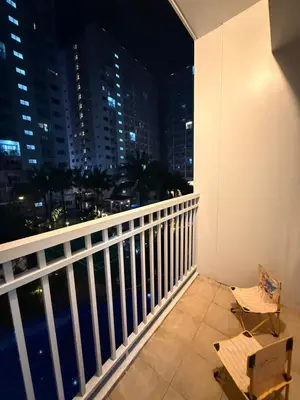 a balcony with a view of the city at night at Wonder Collective Stays in Manila