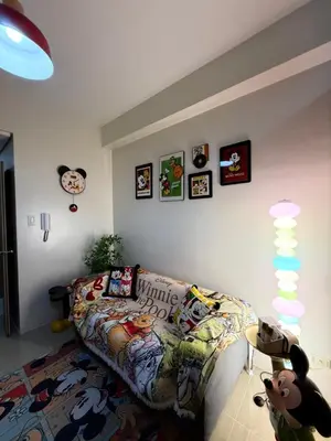 a living room with a couch and some pictures on the wall at Wonder Collective Stays in Manila