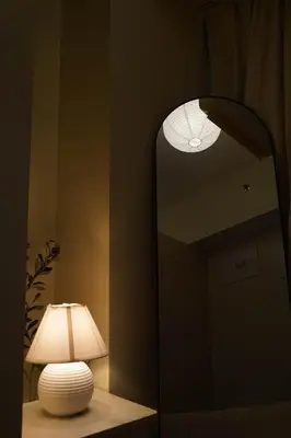 a lamp sitting on a table next to a mirror at SMDC LIGHT Balcony Smart TV Alexa Cozy Retreat in Manila