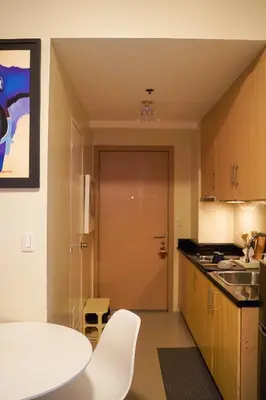 a small kitchen with a white table and a door at SMDC LIGHT Balcony Smart TV Alexa Cozy Retreat in Manila