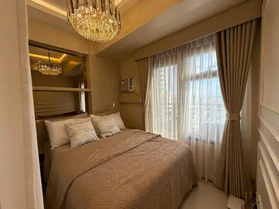 a bedroom with a bed with a chandelier and a window at 2BR Near Manila Bay MOA l Airport with FREE use of Pool l 4 PPL in Manila