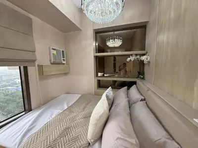 a bed with pillows in a room with a window at 2BR Near Manila Bay MOA l Airport with FREE use of Pool l 4 PPL in Manila