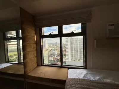 a bedroom with a window with a view of a city at 2BR Near Manila Bay MOA l Airport with FREE use of Pool l 4 PPL in Manila