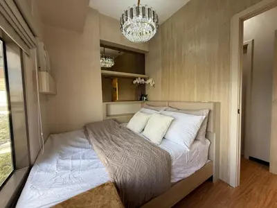 a bedroom with a bed with white pillows and a chandelier at 2BR Near Manila Bay MOA l Airport with FREE use of Pool l 4 PPL in Manila