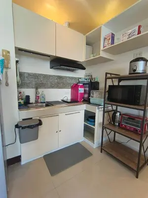a small kitchen with white cabinets and a microwave at BGC Forbes Area Your Home Away From Home in the Heart of BGC with hi-speed Wi-Fi PrimeVideo,Disney ,Netflix in Manila
