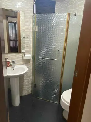 a bathroom with a shower with a toilet and a sink at Staycation by Capri in Manila