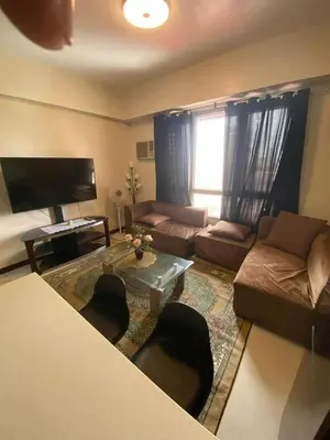a living room with a couch and a table at Staycation by Capri in Manila