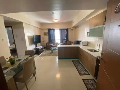 a kitchen and living room with a table and a sink at Staycation by Capri in Manila