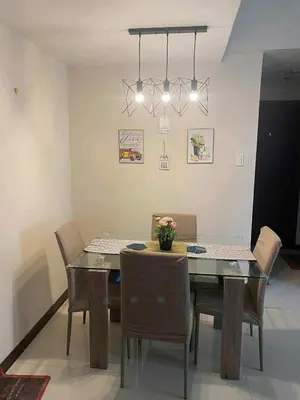 a dining room with a glass table and chairs at Staycation by Capri in Manila