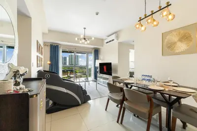 a dining room and living room with a table and chairs at Seaview 2BR CondoteI Near Airport,NAIA, MOA ,Okada Casino in Manila