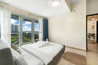 a bedroom with a bed and a large window at Seaview 2BR CondoteI Near Airport,NAIA, MOA ,Okada Casino in Manila