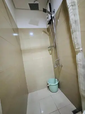 a bathroom with a shower and a bucket at Shore Balcony MOA Price worthy Wifi Pool Netflix in Manila