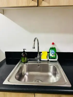 a kitchen sink with soap and a detergent on it at Shore Balcony MOA Price worthy Wifi Pool Netflix in Manila
