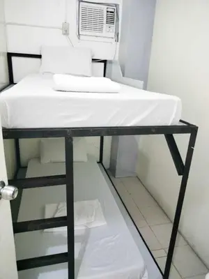 a bunk bed in a small room with a microwave at SL Bedspace Transient House in Manila