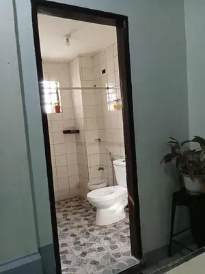 a bathroom with a toilet and a tile floor at SL Bedspace Transient House in Manila