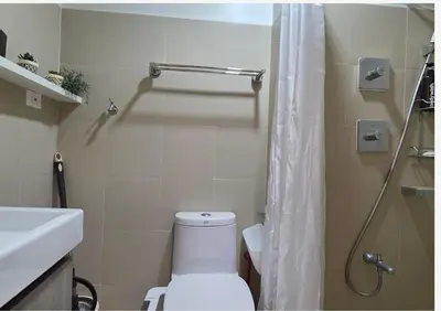 a bathroom with a white toilet and a shower at Posh & Chic Suite 1 Bedroom Mall of Asia Airport in Manila