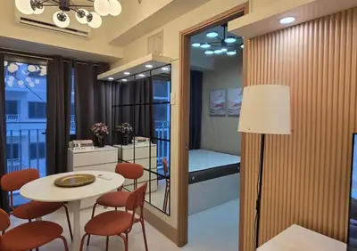 a dining room with a table and chairs and a room with a bed at Posh & Chic Suite 1 Bedroom Mall of Asia Airport in Manila